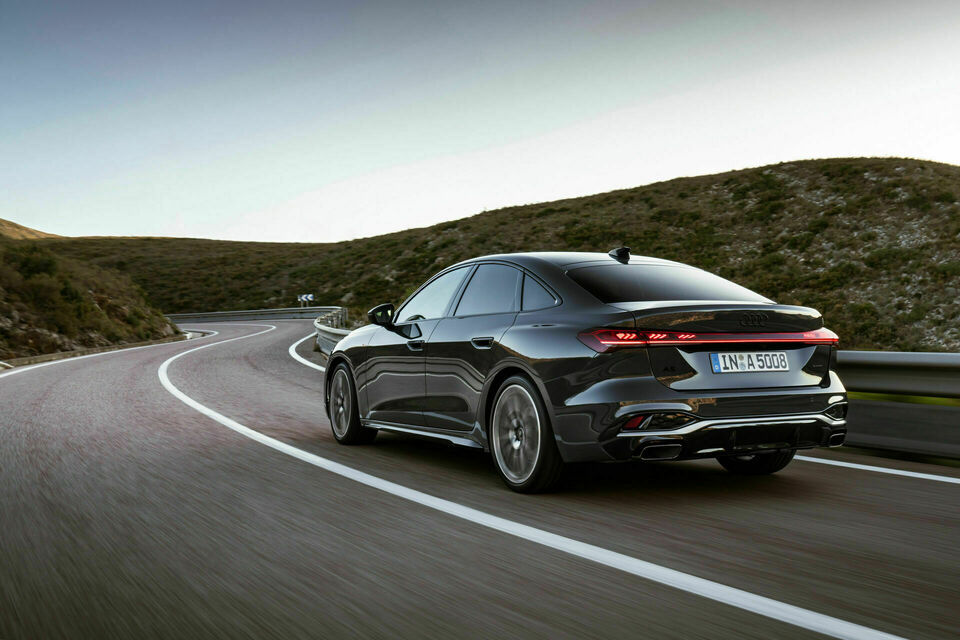 Rear shot of the 2025 Audi A5 driving through mountains